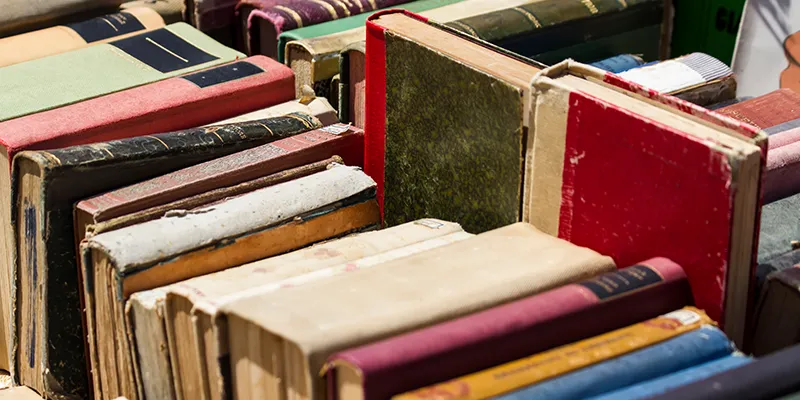 İkinci el kitap alışverişinde sahaf raflarında eski ve nadir kitapları inceleyen bir okur